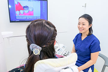 笑顔で患者さんと話す歯科衛生士